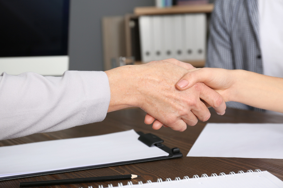 Lawyer shaking hands with client in office