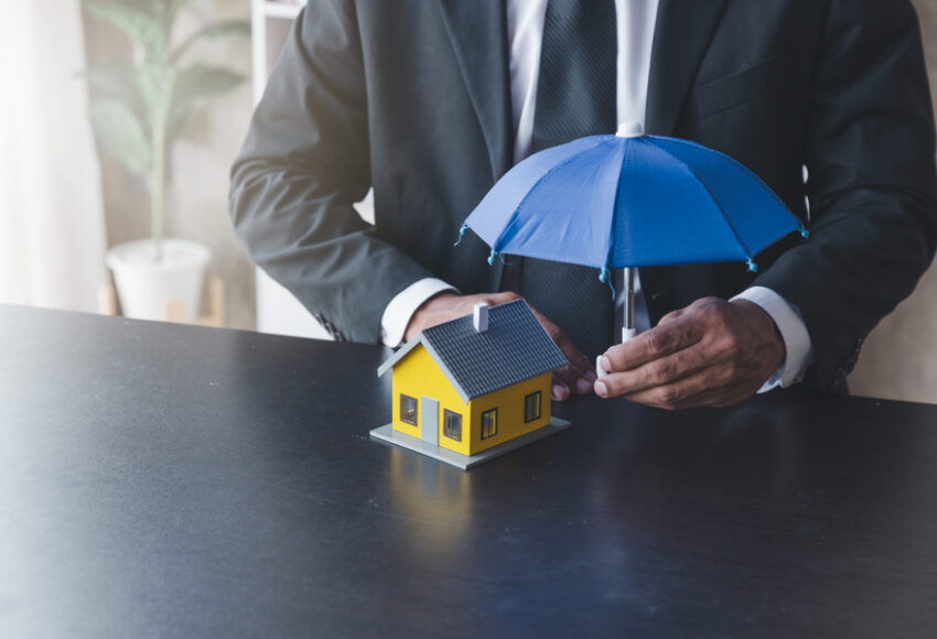 Concept of home insurance, Insurance officer agen use umbrella protecting the house
