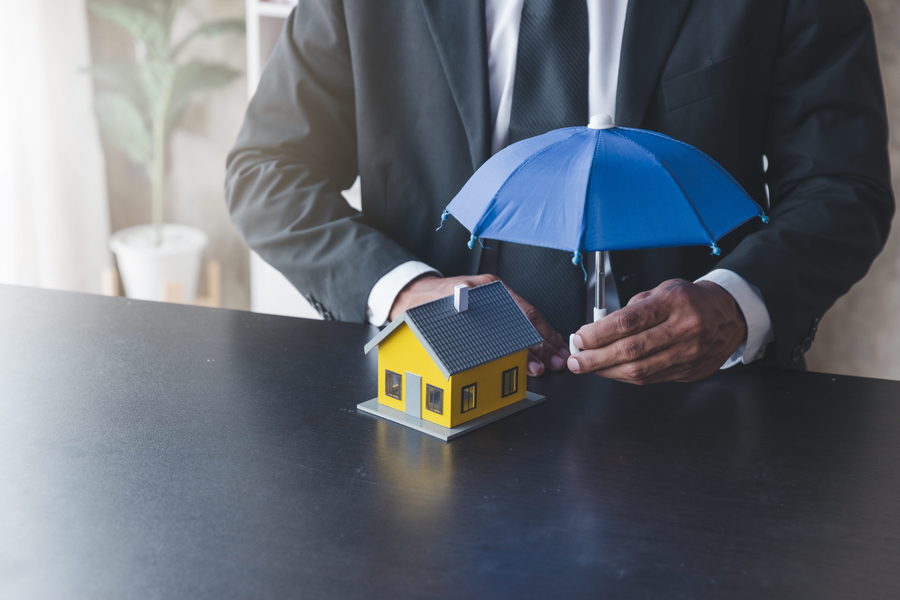 Concept of home insurance, Insurance officer agen use umbrella protecting the house
