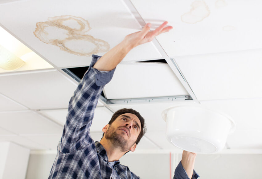 man checking house roof damaged because of roof leak