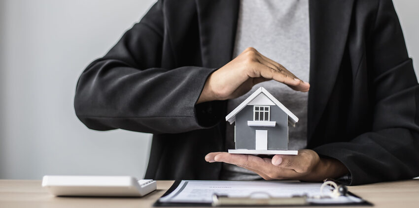 residential claims concept - hands protecting house model