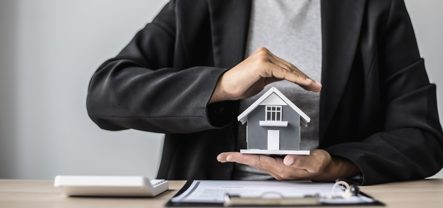 residential claims concept - hands protecting house model
